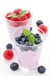two yogurt cups one with rasberry and one with blueberries